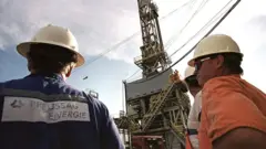 عمال يفحصون المعدات في أحد مواقع استخراج النفط في فنزويلا