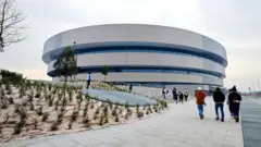 Hockey arena in Milan on Sunday. Рядом идут люди