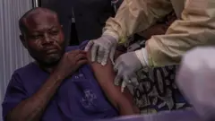 One clinician dey administer di mpox vaccine to one hospital staff member during di launch of di vaccination campaign for di General Hospital of Goma, on October 5, 2024