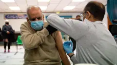 Masud Ahmad, 79, receives an injection of the Oxford/AstraZeneca coronavirus vaccine at the Al Abbas Mosque, Birmingham, which was being used as a Covid vaccination centre