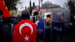 24 Mart'ta İstanbul Beşiktaş'ta polis barikatının önündeki bir eylemci. 
