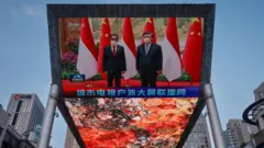 Sebuah layar di pusat perbelanjaan Beijing menunjukan media nasional China menyiarkan pertemuan Presiden Jokowi dan Presiden Xi Jinping