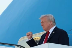 O presidente americano Donald Trump sorri ao sair do avião