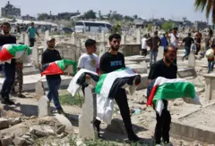 فلسطينيون يحملون رفات جثث خلال حضورهم جنازة 50 شخصاً من ثلاث عائلات قُتلوا خلال حرب غزة، تم انتشال جثثهم مؤخرا من تحت الأنقاض، في مدينة غزة، 20 أغسطس/آب 2026