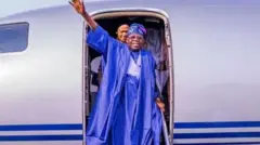 Nigeria President Bola Tinubu wave hands as im bin dey travel