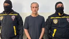 Imagem da prisãoapp de aposta betanoTareck El Aissami, entre dois policiais com rosto coberto