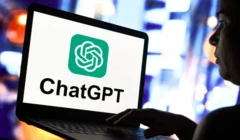 Homme sur ordinateur devant le logo de l'OpenAI