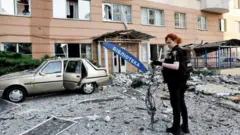 Policial atende prédio atingido por ataque russo em Kiev