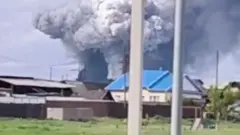 Fumaça sobe sobre a área após o que as autoridades locais chamaram de ataque de drone contra uma unidade militar na vila de Sredny, na Rússia