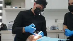 Dentista atente uma pessoa no consultório em Los Algodones