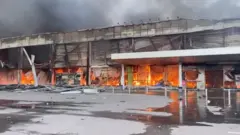 Humo y fuego se elevan desde un centro comercial alcanzado por un misil ruso.