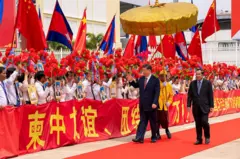 This pool photo taken and released on April 18, 2025 by Agence Kampuchea Presse (AKP) shows China's President Xi Jinping (C-L) walking with Cambodia's Senate President Hun Sen (C-R) past the honour guard upon his departure at Phnom Penh International Airport. 