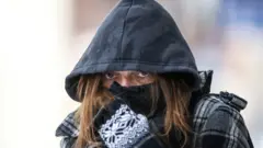 devojka sa kapuljačom i rukavicama po hladnoći