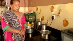 इन्डक्शन चुलोमा चिया पकाउँदै गरेकी महिला