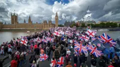 LONDON, ENGLAND - SEPTEMBER 13: Protesters wave Union Jack and St George's England flags during the "Unite The Kingdom" rally on Westminster Bridge by the Houses of Parliament on September 13, 2025 in London, England. Far-right activist Tommy Robinson (also known as Stephen Yaxley-Lennon) has invited supporters to hold a rally in central London entitled "Unite The Kingdom". The former English Defence League leader and his supporters are actively islamophobic and racist and have been behind much of the unrest seen outside hotels housing migrants this summer. Stand Up To Racism are mounting a counter-protest to today's rally.