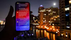 Alerta emitido pelo Ministério do Interior dos Emirados Árabes Unidos, avisando os moradores de Dubai e Abu Dhabi sobre um possível ataque de mísseis iranianos, exibido em um telefone celular pouco antes da interceptação de um míssil em Dubai, no dia 5 de março de 2026.