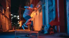 Um jovem caindo de um skate