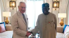 Le roi Charles III serrant la main du président nigérian Tinubu lors de la COP28 en 2025 – Tous deux sourient. 