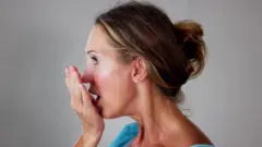 አፏን የምታሸት ሴት 