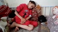 Noora Mohammed sentada encolhida em sofá