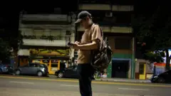 Homem com mochila esperando o ônibus em Buenos Aires.