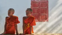 Dois meninos monges junto a uma janela