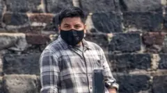 Foto de um homem usando uma máscara preta na boca