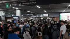 Los viajeros se acumulan en las entradas a los andenes en la temporada alta de viajes.