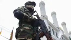 மசூதிக்கு ஒன்றுக்கு வெளியே காவலுக்கு நிற்கும் பாதுகாப்புப் படையினர் (2019ஆம் ஆண்டு)