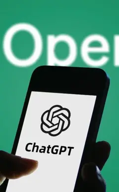 Imagem de uma mão segurando um celular. Na tela está o aplicativo do ChatGPT
