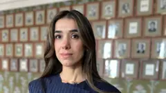Nadia Murad pose devant un mur de photos de lauréats du prix Nobel de la paix à Oslo, en Norvège.
