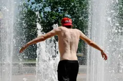 Un joven sin camiseta y una gorra al revés que dice París