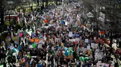 Manifestantes seguram cartazes enquanto marcham pela Naito Parkway durante um protesto “No Kings” contra as políticas do governo do presidente dos EUA, Donald Trump, em Portland, Oregon, em 28 de março de 2026.