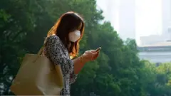 امرأة تضع كمامة لحمايتها من التلوث