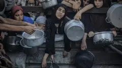 Un grupo de mujeres palestinas esperan agolpadas en Gaza a que les entreguen ayuda humanitaria. 