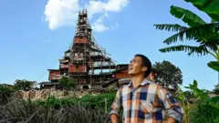 kinez ispred drvene kuće na 10 spratova 