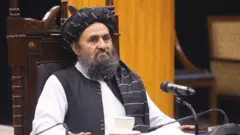 ملا عبدالغنی برادر اخند، معاون اقتصادی ریاست الوزرا حکومت طالبان با لباس سفید و دستار سیاه 