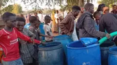 رجال وشباب وسيدات يحاولون الحصول على بعض الماء