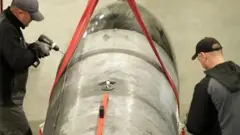 دو نفر در حال کار روی بدنه یک موشک