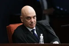 Alexandre de Moraes usando toga preta e olhando para a câmera durante sessão da Primeira Turma do STF