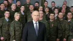 Rais Vladimir Putin akitoa hotuba yake ya mwaka mpya akiwa amezungukwa na watu waliovalia sare