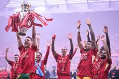 Diogo Jota ergue troféu da Premier League acompanhado de outros jogadores do Liverpool