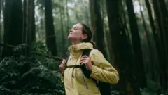 Mujer contemplando en el bosque.