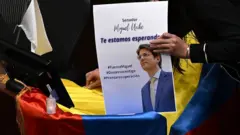 Uma mão segura cartaz com mensagem de apoio a Miguel Uribe, baleado durante um comício na Colômbia