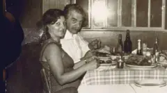 Uma imagem em preto e branco de um homem e uma mulher comendo