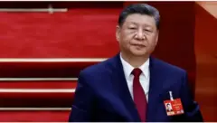 Perezida w’Ubushinwa Xi Jinping arimo areba muri ‘camera’. Yambaye ikositimu. 