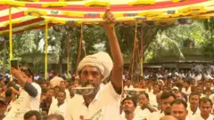 খুলনায় জামায়াতের 'হিন্দু সম্মেলনে' দলটির দাঁড়িপাল্লা প্রতীক হাতে একজন সমর্থক, গতমাসের ছবি