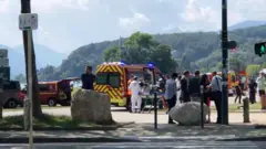 Ambulância no local do ataque com policiais e transeuntes