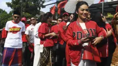 Kader PDI Perjuangan Krisdayanti (kanan) mengikuti pawai budaya menuju Gedung KPU untuk pengajuan bakal calon anggota DPR di Jakarta, Kamis (11/5/2023). 