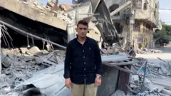 अब्देलहकिम त्याच्या पडलेल्या घरासमोर